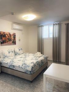 Schlafzimmer mit einem Bett und einem Tisch in der Unterkunft Amigo Hotel On The Beach in Naharija