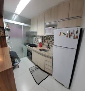 a kitchen with a white refrigerator and a sink at Apto mobiliado -48m² próximo ao shopping Iguatemi in Votorantim