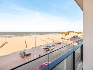 Blick auf den Strand vom Balkon eines Gebäudes in der Unterkunft Winoc 302 luxury family apartment on the dike in Koksijde