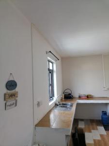 a white kitchen with a sink and a window at Kestrel Appartment in Grand Baie