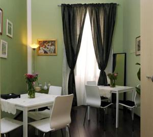 une salle à manger avec deux tables et des chaises blanches dans l'établissement B&B Alexander, à Rome