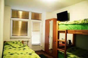 a bedroom with two bunk beds and a television at Hostel Mak in Sarajevo
