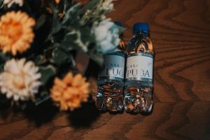 two bottles of alcohol sitting on a table with flowers at Hotel Casa Puga in Oaxaca City