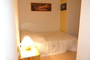 ein Schlafzimmer mit einem Bett und einem Tisch mit einer Lampe in der Unterkunft Appartement près du village, 7 personnes, 2 chambres, 1 mezzanine - CC08 in Beaufort