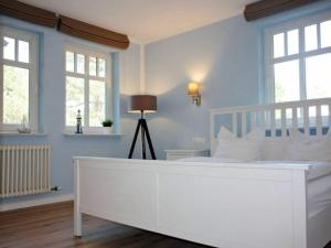 - un lit blanc dans une chambre bleue dotée de fenêtres dans l'établissement Comfy apartment with 1 bedroom and balcony 134, à Binz