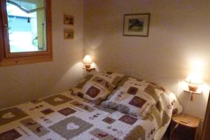 ein Schlafzimmer mit einem Bett mit einer Decke darauf in der Unterkunft Appartement près du village, 7 personnes, 2 chambres, 1 mezzanine - CC08 in Beaufort
