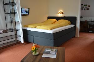 a bedroom with a bed with yellow sheets and a table at KirkeLy Bed and Breakfast in Vester Ulslev