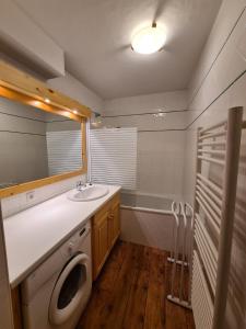 Appartement cosy, 8 personnes, 3 chambres - MONTA01 في بوفورت: حمام مع مغسلة وغسالة ملابس