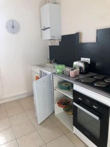 a kitchen with a stove and a white refrigerator at Appartement Les Bons Vivants au coeur de Perrigny in Perrigny-sur-Loire