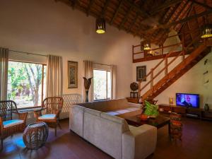 a living room with a couch and a tv at 6-person bush villa at Kruger Park entrance Phalaborwa in Phalaborwa