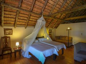 a bedroom with a bed with a mosquito net at 6-person bush villa at Kruger Park entrance Phalaborwa in Phalaborwa