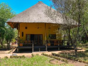 a small yellow building with a thatched roof at 6-person bush villa at Kruger Park entrance Phalaborwa in Phalaborwa
