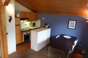 een kleine keuken met een tafel en een kleine tafel en een tafel en een keuken bij Appartement confortable, 6 personnes, 2 chambres, 1 mezzanine - BLD2 in Beaufort