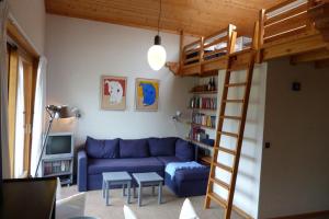 een woonkamer met een blauwe bank en een stapelbed bij Appartement confortable, 6 personnes, 2 chambres, 1 mezzanine - BLD2 in Beaufort