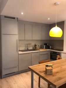 a kitchen with white cabinets and a wooden table at Appartement centre village rénové, 6 personnes, 2 chambres - CL2D in Beaufort