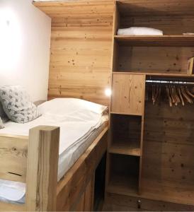 Bett in einem Zimmer mit Holzwänden und Regalen in der Unterkunft Appartement centre village rénové, 6 personnes, 2 chambres - CL2D in Beaufort