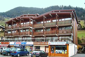 a large building with cars parked in front of it at Appartement centre village rénové, 6 personnes, 2 chambres - CL2D in Beaufort