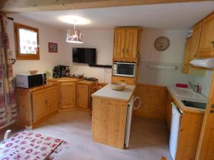 uma pequena cozinha com armários de madeira e um micro-ondas em Appartement centre village, 6 personnes, 2 chambres - VLII71 em Beaufort