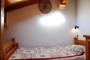 um quarto com uma cama e um relógio na parede em Appartement centre village, 6 personnes, 2 chambres - VLII71 em Beaufort