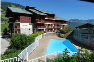 a large apartment building with a swimming pool in front of it at Appartement centre village, 6 personnes, 2 chambres - VLII71 in Beaufort