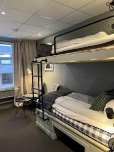 a bedroom with two bunk beds and a window at Hotell Carl Friman in Motala