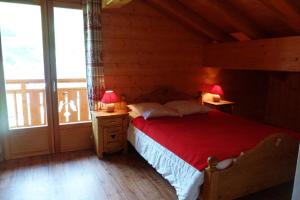a bedroom with a bed with a red blanket and two lamps at Chalet ambiance montagne, 10 personnes, 4 chambres - CH15 in Beaufort