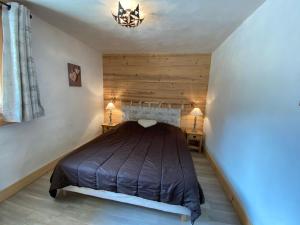 een slaapkamer met een bed en een kroonluchter bij Chalet neuf, 8 personnes, 3 chambres - CH32 in Beaufort