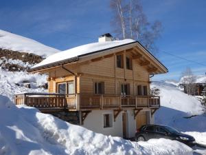 uma cabana de madeira na neve com um carro em Chalet neuf, 8 personnes, 3 chambres - CH32 em Beaufort