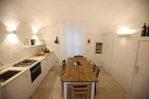 uma cozinha com uma mesa de madeira e um fogão forno superior em I Tre Coni by Acqua di Puglia em Locorotondo