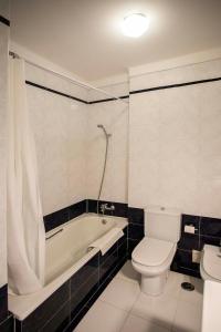 een badkamer met een toilet, een bad en een wastafel bij Apartamento com vista castelo in Setúbal