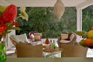 d'une terrasse avec des chaises en osier et une table avec des boissons. dans l'établissement Villa Allegra - Teloni, à Bibbona