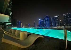 - une piscine avec vue sur la ville la nuit dans l'établissement Waterfront apartment with Burj Khalifa views in Business Bay, à Dubaï