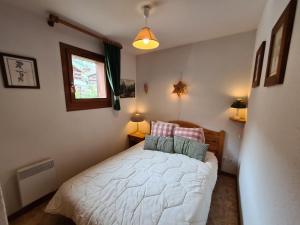 a bedroom with a white bed with two pillows at Appartement chaleureux, 6 personnes, 3 chambres - MER05 in Beaufort
