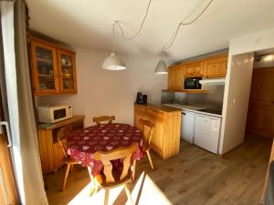 - une cuisine avec une table et un four micro-ondes dans l'établissement Appartement cosy, 6 personnes, 2 chambres - MER11, à Beaufort