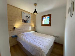 - une chambre avec un lit et une photo de cerf sur le mur dans l'établissement Appartement cosy, 6 personnes, 2 chambres - MER11, à Beaufort