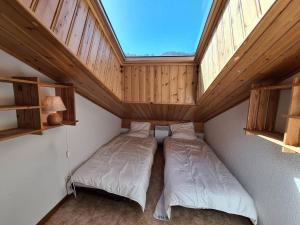 two beds in a small room with a skylight at Appartement spacieux, 6 personnes, 3 chambres - MER13 in Beaufort