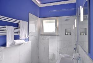 une salle de bain bleue avec une douche et un lavabo dans l'établissement Villa Pandora - Teloni, à Bibbona 43 autres photos