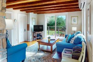 uma sala de estar com um sofá azul e uma mesa em Country Cottage em Indian Point