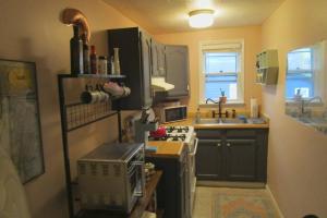 Il comprend une petite cuisine équipée d'une cuisinière et d'un évier. dans l'établissement Boho-Chic Retreat - Unit 3, à Bloomington