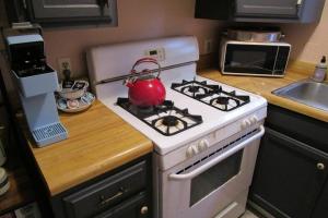 uma cozinha com um fogão branco e uma chaleira para chá em Boho-Chic Retreat - Unit 3 em Bloomington
