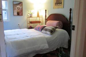 a bedroom with a large bed with white sheets at Boho-Chic Retreat - Unit 3 in Bloomington