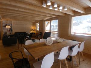 a dining room with a wooden table and white chairs at Chalet cosy près des pistes, 12 personnes, 4 chambres - CH41 in Beaufort