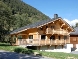 a log cabin with a wrap around deck at Chalet cosy près des pistes, 12 personnes, 4 chambres - CH41 in Beaufort