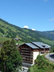 a building on a hill with a mountain at Appartement centre village, 4 personnes, 1 chambre, 1 coin montagne - VLI21 in Beaufort +2 photos