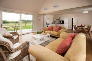 a living room with a couch and chairs and a table at Coldwells Farmhouse in Dalkeith