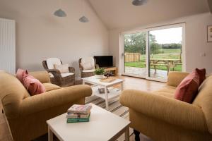 a living room with two couches and a tv at Coldwells Farmhouse in Dalkeith