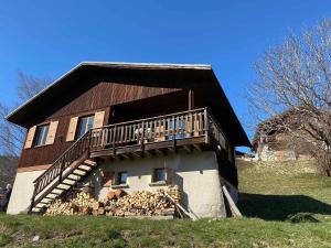 a house with a balcony and a pile of wood at Chalet vue panoramique, 11 personnes, 5 chambres - CH47 in Beaufort
