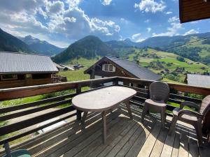 a table and chairs on a deck with a view of mountains at Chalet proche des commerces, 6 personnes, 2 chambres - CH16 in Beaufort