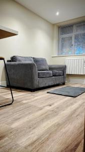 a living room with a couch and a wooden floor at Abbey House in Horsham