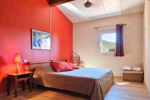 Dormitorio rojo con cama y ventana en U Casinu en Piana